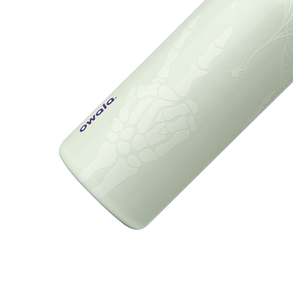 Owala FreeSip 32oz in RIP, close-up of pale mint insulated stainless steel body with white skeleton hand, spider web, and spider glow print, dark purple owala wordmark; glows in the dark